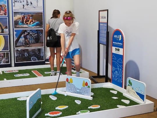 Emma Francus, 10, of Detroit, Michigan, plays mini golf at Indiana's golf-themed exhibit at...
