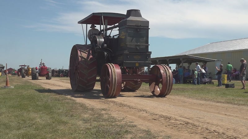 A large tractor drives in the threshing bee parade.